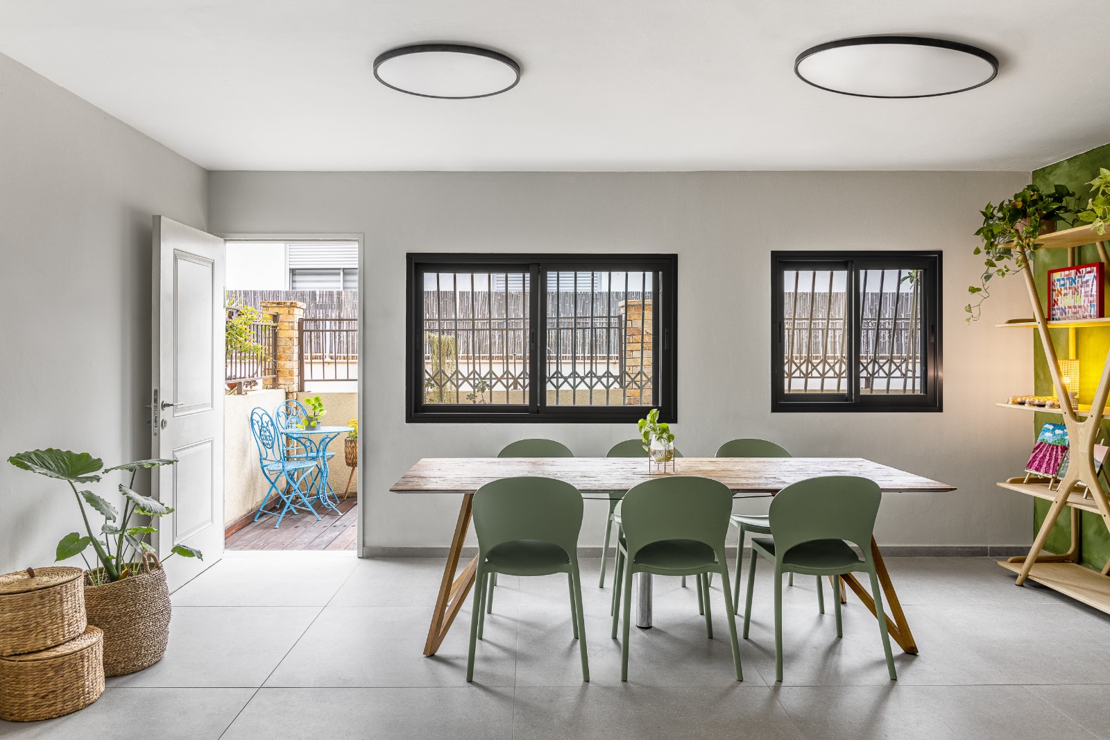 חדר היצירה המרכזי של סטודיו ArtyParty — שולחן עץ, כיסאות ירוקים, חלונות גדולים ואוירה מזמינה